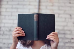 Book in front of girl's face