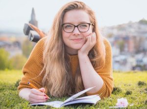 Smiling woman writing in notebook