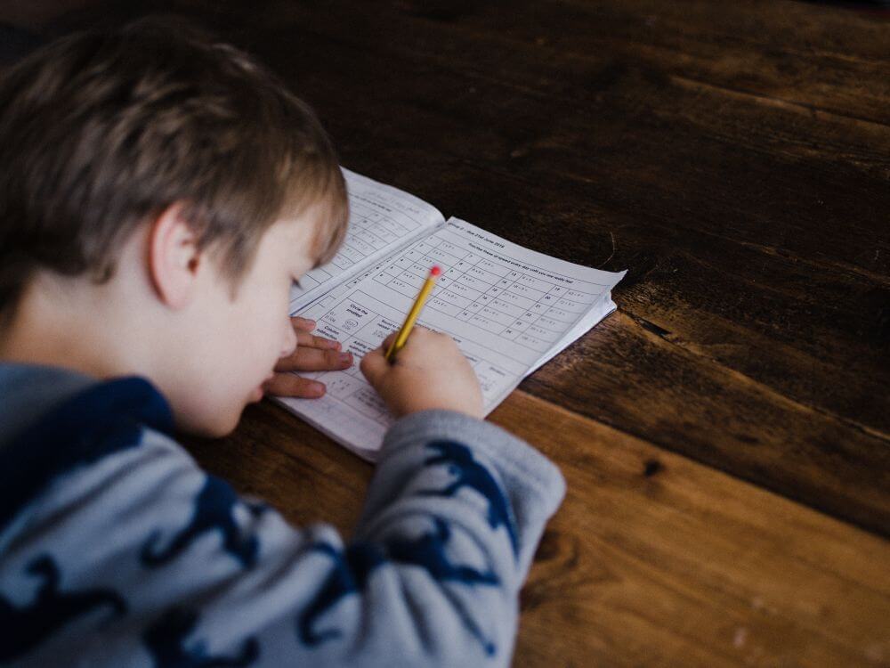 Young student  with aa pencil and workbook struggling with a school reading assignment